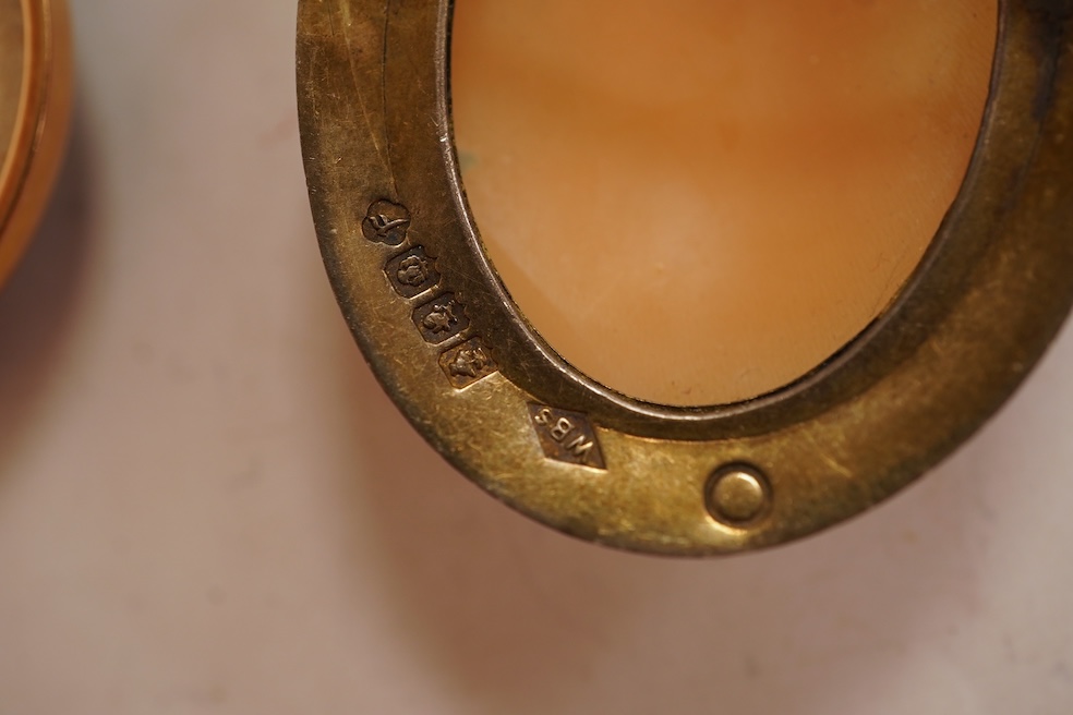 A Satsuma brooch, set with a circular Satsuma plaque depicting an oiran with gilded hair ornaments, mounted in 9ct gold, 3.3cm diameter, British hallmarks; together with an oval shell cameo brooch depicting a classical w